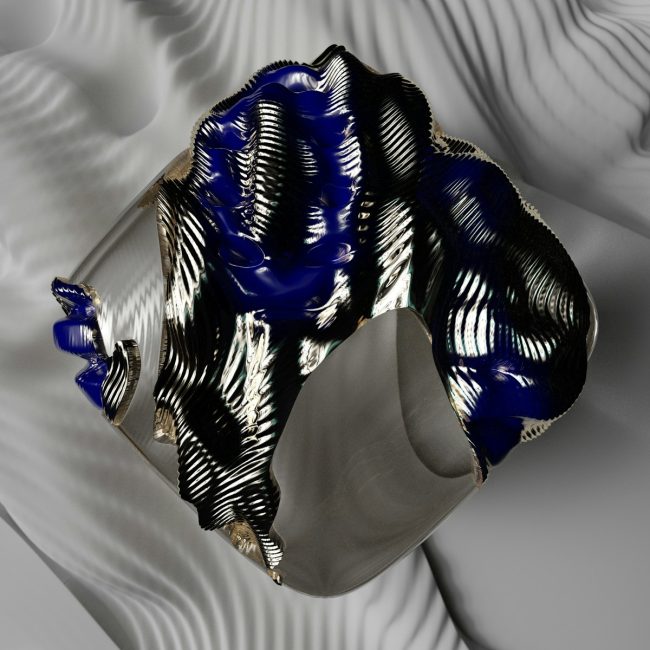 a silver and blue vase sitting on top of a table